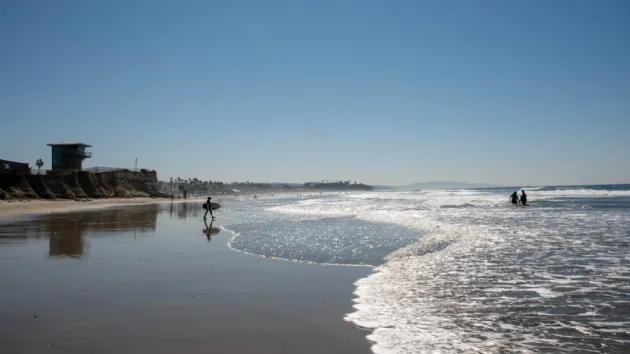 Lone Surfer Walking Out for a Surf at San Elijo State Beach